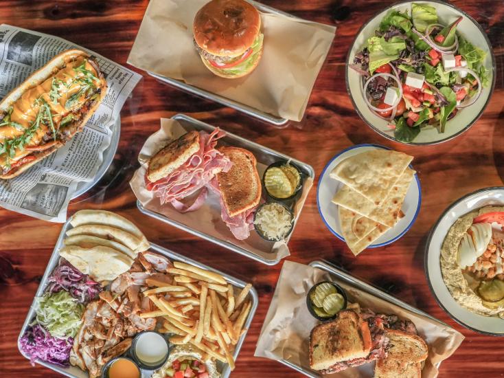 Spread of different meals, including sandwiches, salads, and fries, from Gili's Kitchen in Jacksonville Florida.